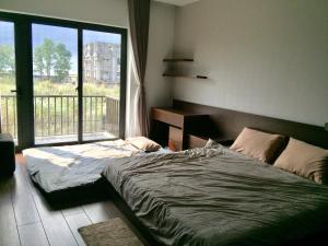 a bedroom with a bed and a large window at Full House The Villa Hạ Long 5PN Karaoke Bida BBQ 18 Khách in Ha Long