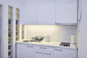 una cocina blanca con fregadero y armarios blancos en Zagreb Spin&Fly, en Zagreb