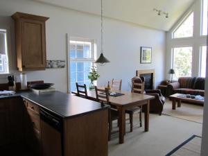 a kitchen and living room with a table and chairs at 203 at Water's Edge in Ucluelet