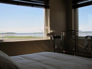 a bedroom with a bed and a view of the ocean at Hôtel Saint-Germain Rimouski in Rimouski