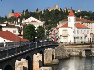 a bridge over a river with buildings and a castle at A Gosto in Tomar