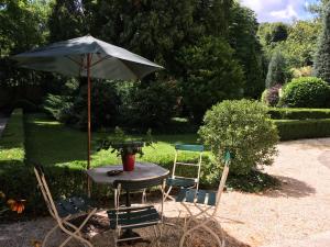 einen Tisch und zwei Stühle mit Sonnenschirm in der Unterkunft Buda Hills villa apartment in Budapest