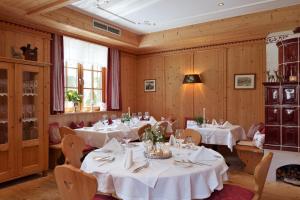 uma sala de jantar com mesas e cadeiras com toalhas de mesa brancas em Haus Christoph em Maria Alm am Steinernen Meer