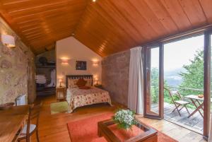 a bedroom with a bed and a large window at Quinta De Abol De Baixo in Entre-os-Rios