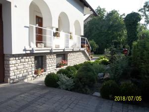 a house with a balcony and a garden at Virágos Vendégház Balatonfüred in Balatonfüred