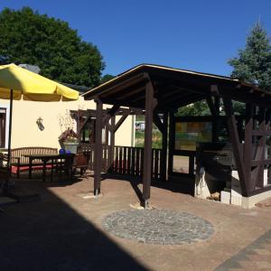 a wooden pavilion with a table and a yellow umbrella at Landgasthaus Konig in Stephanshausen