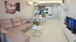 ein Wohnzimmer mit einem Sofa und einem Tisch in der Unterkunft Oasis Beach X app 25 in Guardamar del Segura