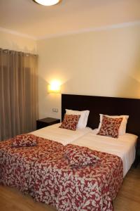 Habitación de hotel con 2 camas con sábanas rojas y blancas en Paço Lafões, en Termas de Sao Pedro do Sul