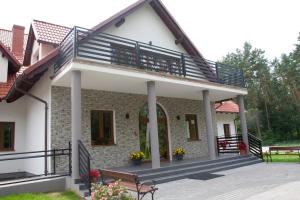 a house with a balcony and a porch at Mazurska Osada in Kleszczewo