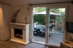 een woonkamer met een open haard en een glazen schuifdeur bij Chalet Vakantie Wageningen Veluwe in Wageningen