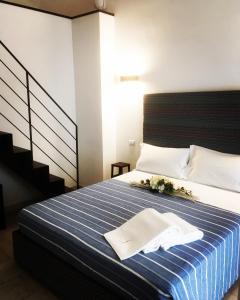 a bedroom with a bed with a blue and white striped blanket at B&B Salentus in Gallipoli
