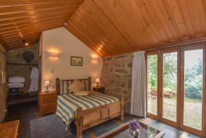 um quarto com uma cama e um tecto de madeira em Quinta De Abol De Baixo em Entre-os-Rios