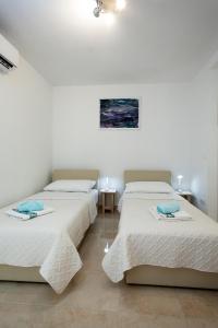 two beds in a room with white walls at King's Garden Studio in Split