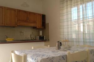 uma cozinha com uma mesa com cadeiras e uma janela em The Garden em Tortolì