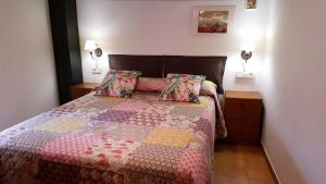 een slaapkamer met een bed met een kleurrijke quilt bij Casa Templers in Horta de San Joan