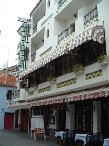 um edifício com mesas e cadeiras em frente em Hotel La Cala em Roses