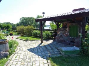 eine Steinterrasse mit einem Pavillon im Garten in der Unterkunft Pluszkiejmy 44 in Pluszkiejmy