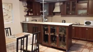 a kitchen with a counter and a table with chairs at Садиба у Вишкові in Vyshkiv