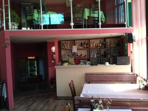 uma sala de jantar com uma mesa e um bar em семеен хотел "НЕВЕН" em Momin Prohod