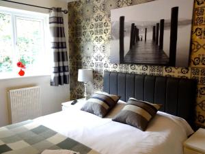 a bedroom with a bed and a boardwalk picture on the wall at Abbey Grange Hotel in Nuneaton