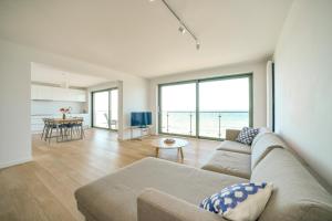 a living room with a couch and a view of the ocean at Premium Cliff Apartament - Ustronie Morskie in Ustronie Morskie