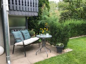 a patio with a chair and a table in a yard at Ferienwohnung vor den Toren Berlins in Heidesee