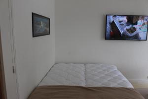 a bed in a room with a picture on the wall at TY TREZ Magnifique vue mer à Bénodet 10 Avenue de la Plage Résidence "Les Glénan" in Bénodet