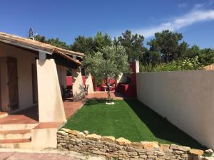 a garden with a stone wall and a yard at villa fleur de sel in Cuges-les-Pins