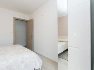 um quarto com paredes brancas e uma cama e um espelho em Ninas em Visnjan