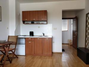a kitchen with wooden cabinets and a table in a room at Morski Briz in Balchik