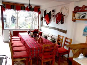a dining room with a red table and chairs at Chardaka Guest House in Kalofer
