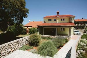 a house with a stone retaining wall and a driveway at Apartments Mester in Sveti Anton