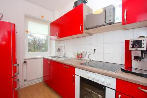 ハノーファーにあるComfort Apartments close to Hannover Exhibitionの赤いキッチン(赤いキャビネット、シンク付)