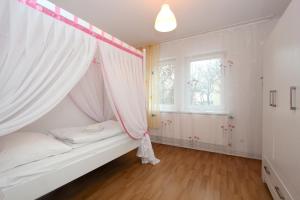 ハノーファーにあるComfort Apartments close to Hannover Exhibitionのベッドルーム(蚊帳付きのベッド付)