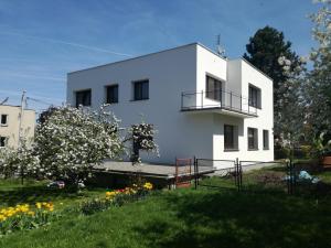 a white building with a balcony on top of a yard at Apartament Mamamiry in Głuchołazy