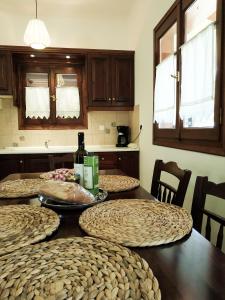 a table with four chairs and a bottle of wine at Villa Conifera in Zakynthos