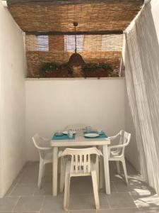 una mesa blanca y sillas en una habitación en I quartini, en Maruggio