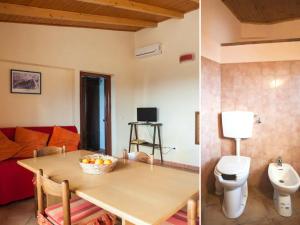 a living room with a table and a toilet at Vasari in Santa Lucia del Mela