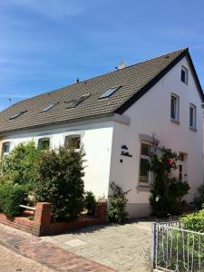 a white house with a black roof at Altes Zollhaus in Borkum +8 photos