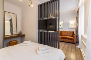 スプリトにあるNephelae Boutique Roomsのベッド、テレビ、ソファが備わる客室です。