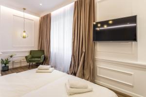 スプリトにあるNephelae Boutique Roomsのベッドと薄型テレビがあるホテルの部屋