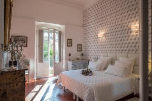 um quarto com uma cama branca e uma parede de tijolos em Les suites de Peyrat em Pézenas
