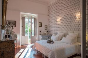 a bedroom with a white bed with a brick wall at Les suites de Peyrat in Pézenas