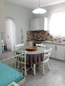 a kitchen with a table and chairs and a sink at Myconian Cottage in Ano Mera