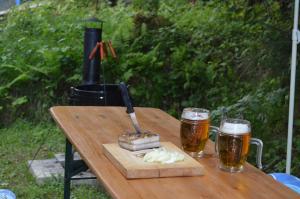 a wooden table with two glasses of beer and a knife at Chata Adrian Slovak Paradise in Spišské Tomášovce