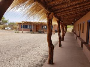 een gebouw met een rieten dak en een stoep bij Andes Nomads Desert Camp & Lodge in San Pedro de Atacama