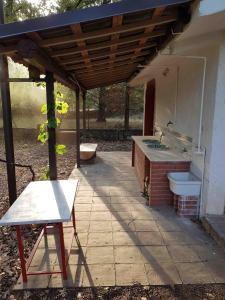 una cocina al aire libre con aseo bajo una pérgola de madera en Chalet Villa Fini, en Fleri
