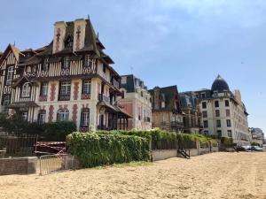 un antiguo edificio en una playa frente a los edificios en Appartement Trouville Plage, en Trouville-sur-Mer