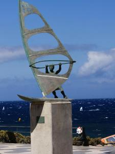 uma estátua de um homem numa vela numa prancha de surf em Pozo Izquierdo Global Paradise em Pozo Izquierdo