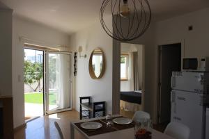 a kitchen and dining room with a table and a refrigerator at Encosta´s Garden in Oeiras